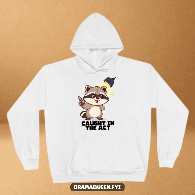 Funny hoodie showing a mischievous raccoon pointing to a spotlight overhead, embodying playful guilt and humorous drama.